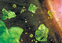 Так художник представляет себе микроскопические кристаллы оливина, содержащиеся в пылевом диске, окружающем коричневого карлика. Изображение NASA