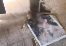Сирийский повстанец топчет портрет Асада. Алеппо, август 2016. Кадр видео, помещенного Reuters