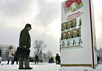 Белорусский избиратель перед портретами кандидатов в президенты, Минск. Фото АР