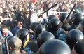 Полицейские, в числе которых и "потерпевший" от Кривова омоновец Куватов, избивают через загородки демонстрантов (эпизод, вмененный Сергею Кривову)