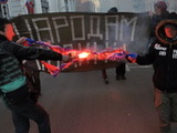 Активисты Национал-революционного блока сжигают флаг "Новороссии" на антивоенном марше. Фото с ФБ-страницы Михаила Пулина