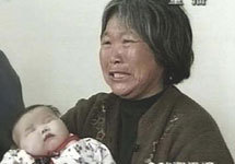 Женщина с заболевшим младенцем в больнице Фуяна. Фото АР