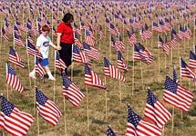 A woman and her son walk through a sea of more than 3,000 U.S. flags displayed outside the Hope Church in Mason, Ohio, Sept. 10,
