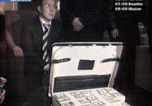 Арестованный сотрудник ФНС Олег Алексеев и чемодан с долларами, переданный ему в виде взятки. Кадр Euronews