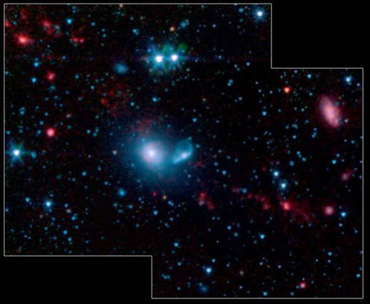 Система NGC 5291. Псевдоцветное изображение, где длина волны в 3,6 микрона соответствует синему цвету, 4,5 мк - зеленому, 5,8 мк - оранжевому и 8,0 мк - красному. Источники с яркой PAH-эмиссией, в том числе и приливно-отливные карликовые галактики TDGs, здесь носят красноватый оттенок. Изображение NASA/JPL-Caltech/Cornell Univ