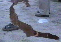 Кровь на асфальте. На месте  взрыва в Кербеле, Ирак. Кадр телеканала "Аль-Иракия"