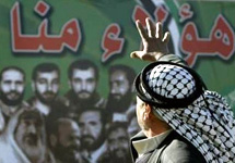 Сторонник Хамаса на фоне предвыборных плакатов. Фото Reuters