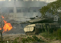 Израильский танк ведет огонь по зданию тюрьмы. Фото AFP