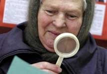 Выборы в Белоруссии. Пожилая избирательница изучает бюллетень. Фото АР