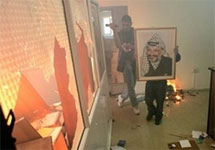 Фатховец спасает из огня портрет Ясира Арафата. Фото АР