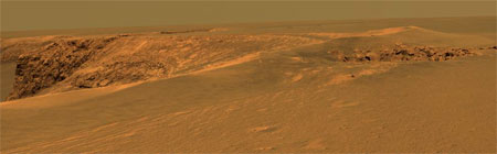 Это вид кратера Виктория в районе так называемой "Утиной бухты" ("Duck Bay"), снятый Opportunity 28 сентября 2006 года с помощью панорамной камеры Pancam так, как это бы увидел человеческий глаз. Небольшой 18-метровый кратер на переднем плане справа получил неофициальное прозвище "Спутник" ("Sputnik"). Фото NASA/JPL/Cornell с сайта nasa.gov/mission_pages/mer/ (под картинкой находится ссылка на изображение с большим разрешением)