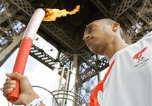 Олимпийский огонь, спортсмен Стефан Диагана и Эйфелева башня. Фото АР