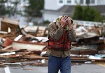 Житель штата Нью-Йорк у развалин своего дома. Фото АР