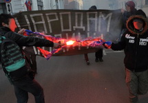 Активисты Национал-революционного блока сжигают флаг "Новороссии" на антивоенном марше. Фото с ФБ-страницы Михаила Пулина
