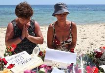 Туристки молятся на месте атаки террориста в Сусе. Фото: sbs.com.au