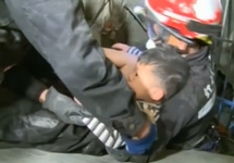 Мальчик, спасенный из-под завалов 17-этажки в Тайнане. Кадр Reuters