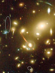 Новая галактика (распавшаяся на два изображения, помеченные эллипсом и кругом) была обнаружена на этой фотографии, полученной ка