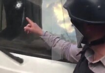 Отверстие от пули на стекле автобуса российских пропагандистов. Кадр РЕН-ТВ