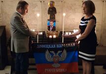 Юбер Файяр зажигает свечу в память Александра Захарченко. Фото из твиттера политика