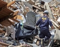 Разбор завалов на месте разрушенных домов в поисках жертв