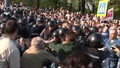 Илья Гущин тянется рукой к полицейскому. Кадр видеозаписи "Nevex TV" из "Болотного дела"