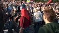 Полицейский Антонов замахивается дубинкой на девушку. Гущин стоит в стороне. Кадр видеозаписи "Nevex TV" из "Болотного дела"