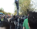 Омоновец не подпускает его, размахивая дубинкой. Справа бьют Луцкевича и других демонстрантов.