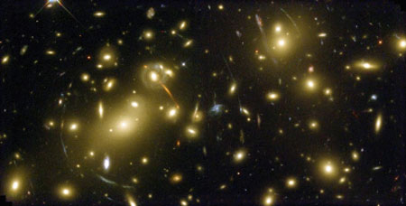 Скопление галактик Abell 2218 настолько массивно, что увеличивает и искажает изображения далеких галактик, которые наблюдаются в виде "дуг", разбросанных по всему снимку. Фото NASA/HST с сайта www.jb.man.ac.uk