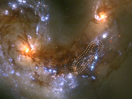 Сталкивающиеся галактики, носящие название "Антенны" (NGC4038/4039), находящиеся от нас на расстоянии 60 миллионов световых лет в созвездии Ворона. Области, содержащие возбужденный газ, обведены белыми пунктирными линиями. Новые звезды начнут формироваться там в течение ближайших миллионов лет. Фото ESA/NASA (оптический диапазон - "Хаббл") с сайта www.esa.int